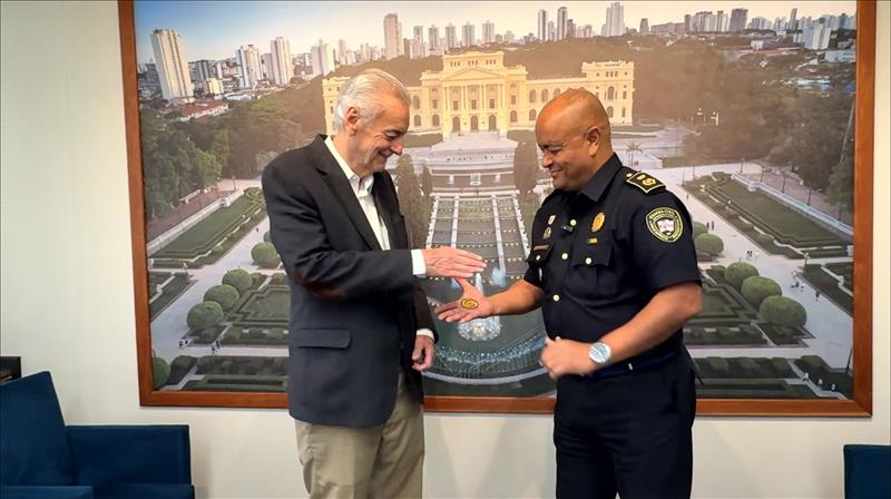 Momento da entrega da moeda com o tradicional aperto de mão. 